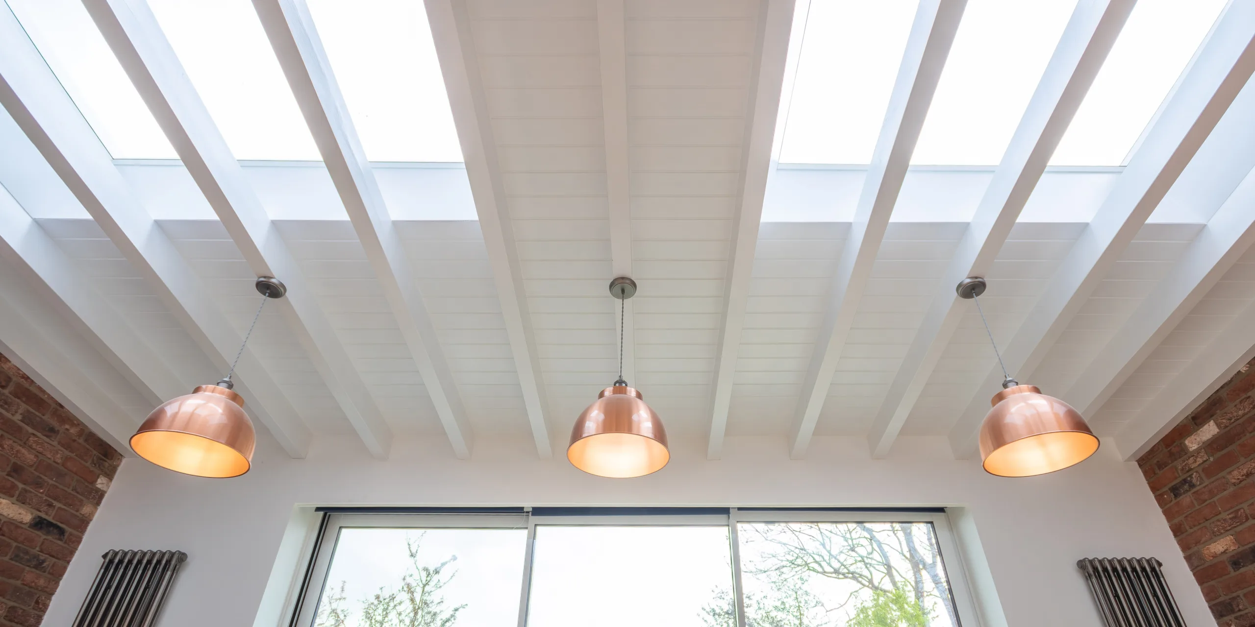 Rooflights and exposed rafters in Victorian rear extension in Redhill Surrey bringing natural light into kitchen and dining space